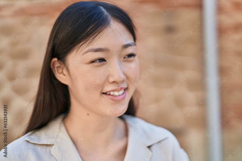 Chinese woman smiling confident looking to the side at street Chinese woman smiling confident looking to the side at street
