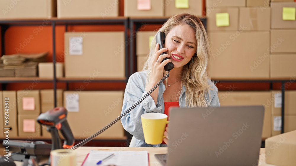 Young blonde woman ecommerce business worker talking on telephone drinking coffee at office Young blonde woman ecommerce business worker talking on telephone drinking coffee at office