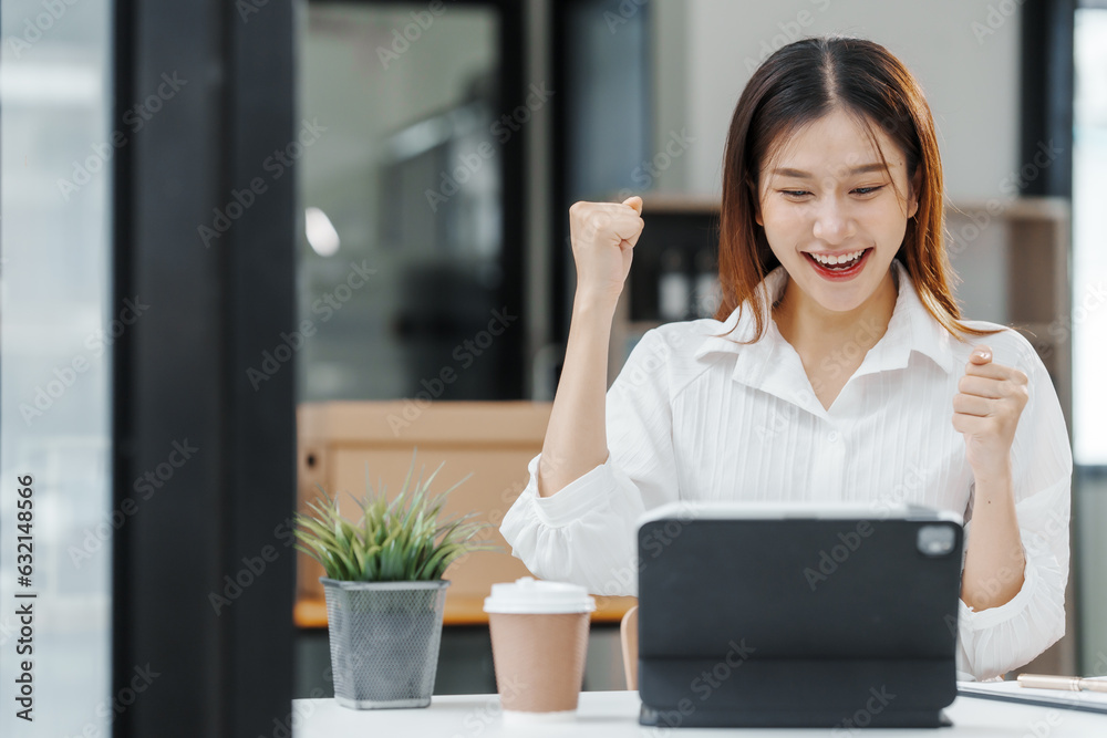 Excited Female secretary business woman in South Korean workplaces, feeling euphoric celebration online win success achievement result rejoicing over good news, raise up hands, good email news