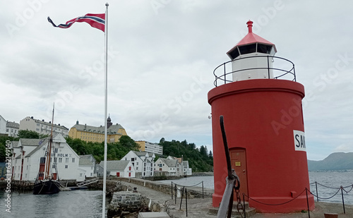 Molja Lighthouse in old port of Alesund, Norway. Molja lihgthouse in the front of Olaf Holf warehouse building, Fisheries Museum(fishing industry). photo