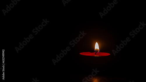a burning candle against a dark background