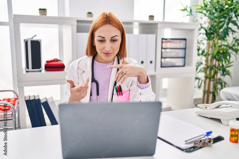 Young caucasian woman doctor having video call sitting on table at clinic Young caucasian woman doctor having video call sitting on table at clinic