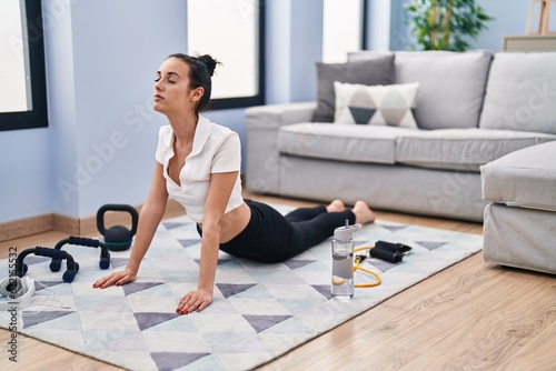 Young caucasian woman training yoga exercise at home