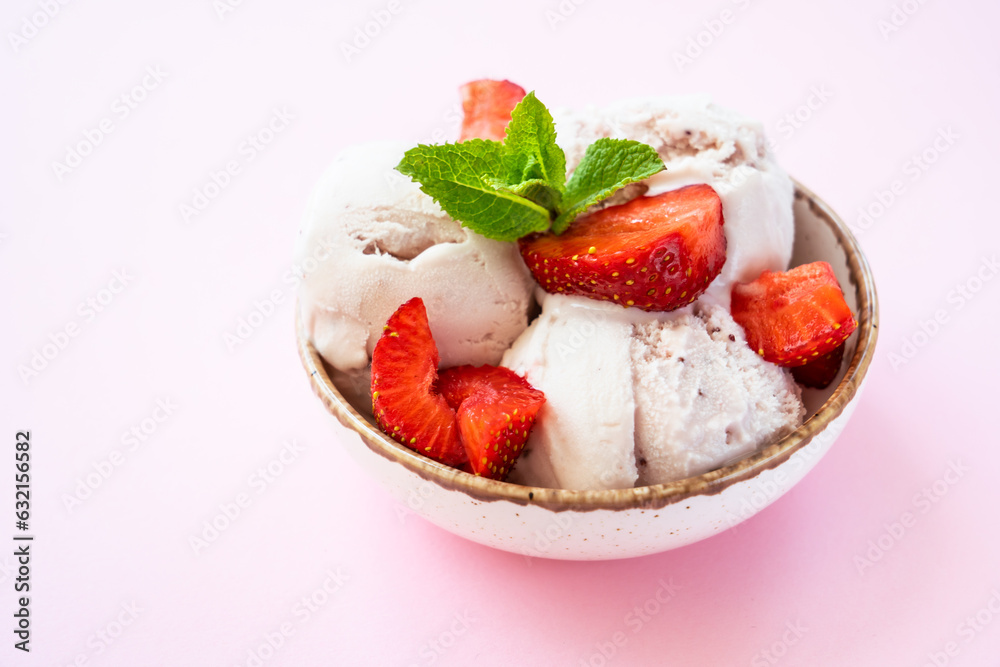 Homemade ice cream with fresh strawberries on pink background. Close up. Homemade ice cream with fresh strawberries on pink background. Close up.