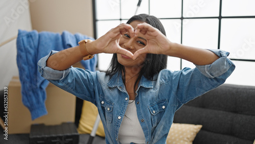 African american woman doing heart gesture at new home