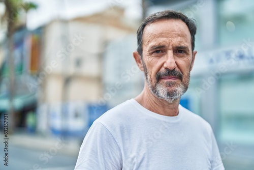 Middle age man standing with serious expression at street