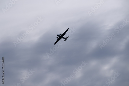 Fotografie, Obraz An old propeller passenger airplane flying against a cloudy morning sky