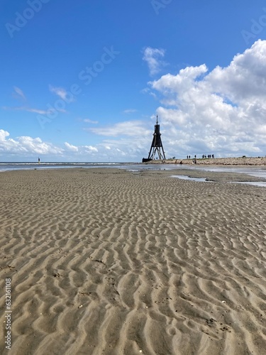 Landschaft an der Nordsee bei einer Wattwanderung vor Cuxhaven bei nahender Flut mit Blick auf die Kugelbake photo