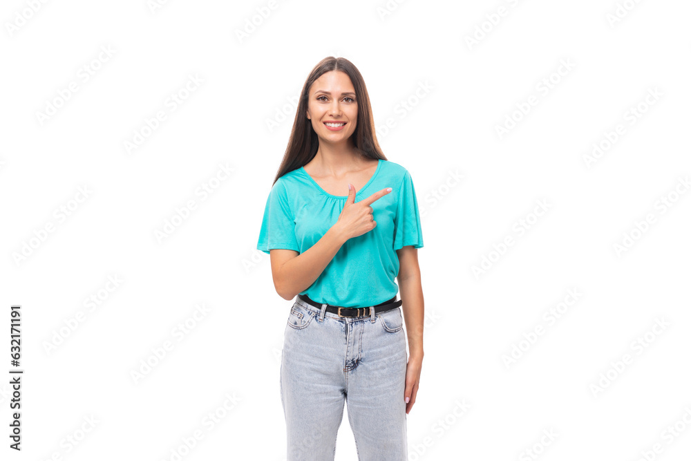 young well-groomed caucasian brunette woman with long hair in a blue t-shirt points her hand to the side on an isolated white background with copy space young well-groomed caucasian brunette woman with long hair in a blue t-shirt points her hand to the side on an isolated white background with copy space