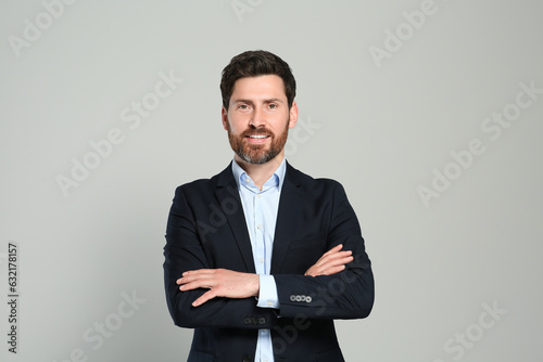 Handsome real estate agent in nice suit on grey background