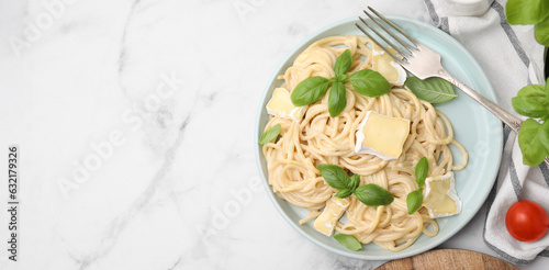 Tasty pasta with brie cheese served on white marble table, flat lay. Banner design with space for text