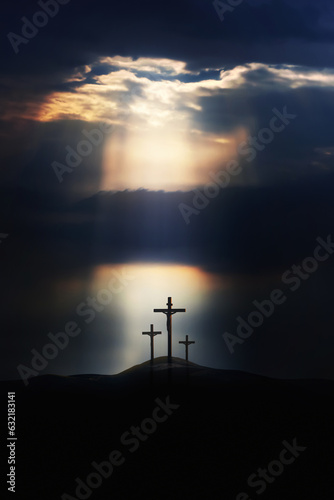Bright light shining through clouds, dramatic and majestic sky, hill of Golgotha during Passion Week, cross silhouette symbolizing the passion of Jesus Christ and death of Jesus, and Easter background