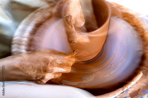 Dynamic image with blur of a pot being thrown on a potter's wheel emphasizing movement