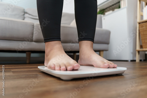 Fat diet and scale feet standing on electronic scales for weight control. Measurement instrument in kilogram for a diet control.