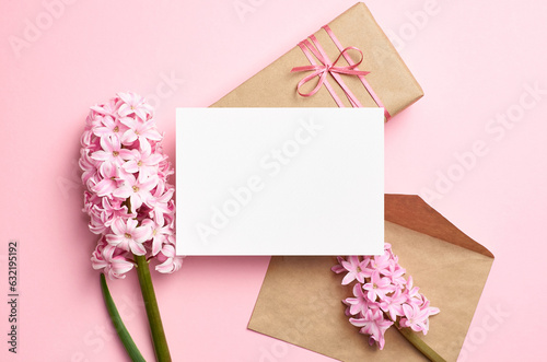 Blank greeting card mockup with envelope, gift box and flowers, white card mock up with copy space © nikavera