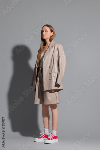 Stylish woman wearing red classic old school sneakers on light gray background