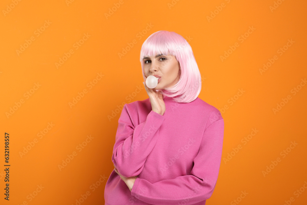 Beautiful woman blowing bubble gum on orange background Beautiful woman blowing bubble gum on orange background