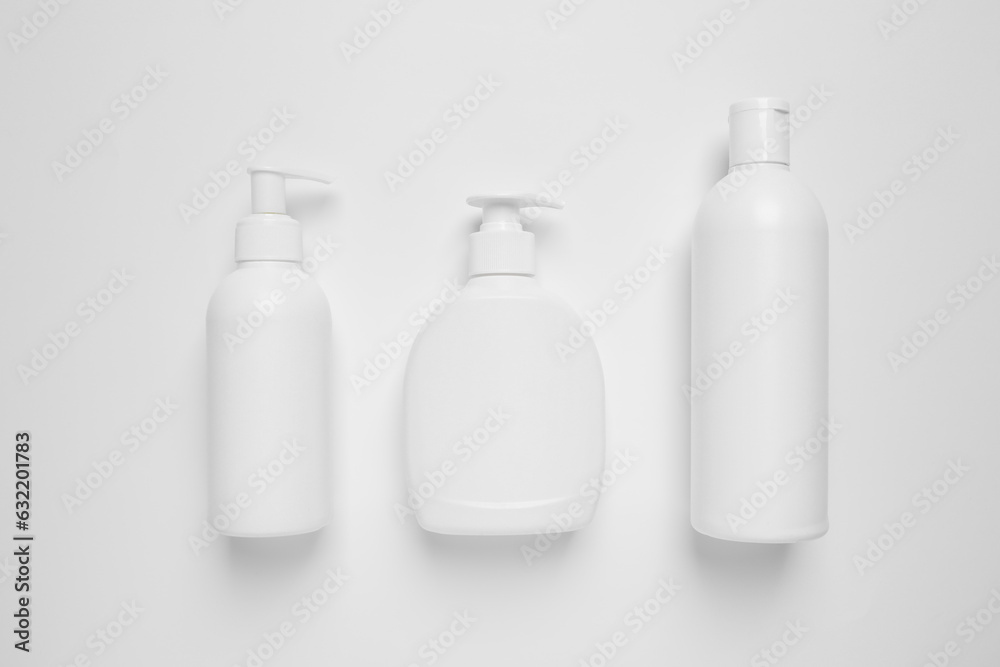 Bottles with different cosmetic products on white background, flat lay Bottles with different cosmetic products on white background, flat lay