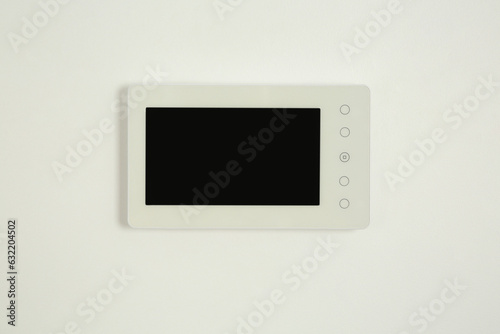 Modern video intercom hanging on white wall