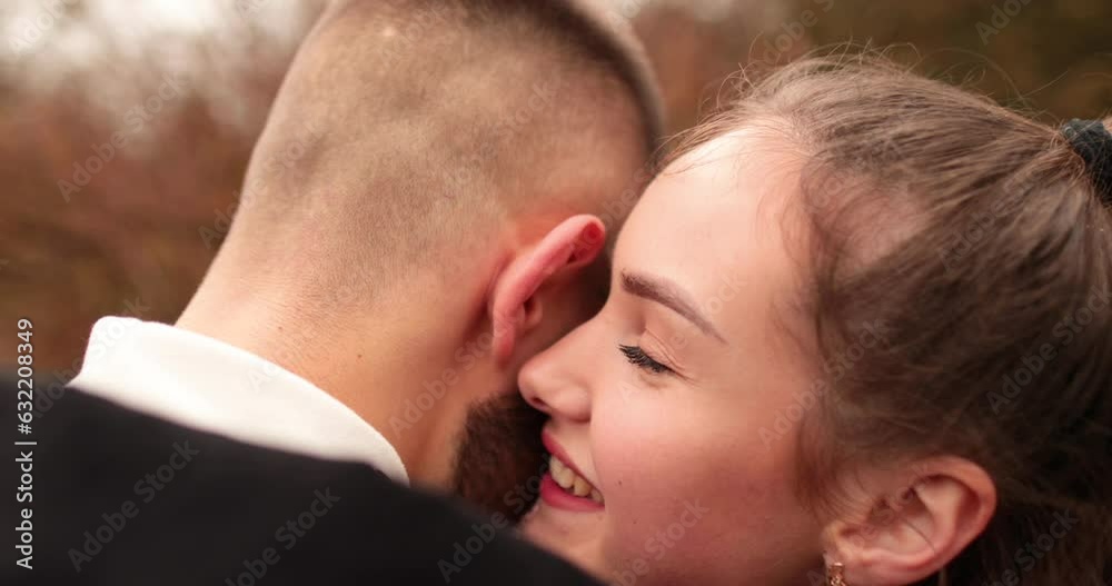 Close-up of the faces of a young couple in love kissing and hugging on the street on a gloomy autumn day. Close-up of the faces of a young couple in love kissing and hugging on the street on a gloomy autumn day.
