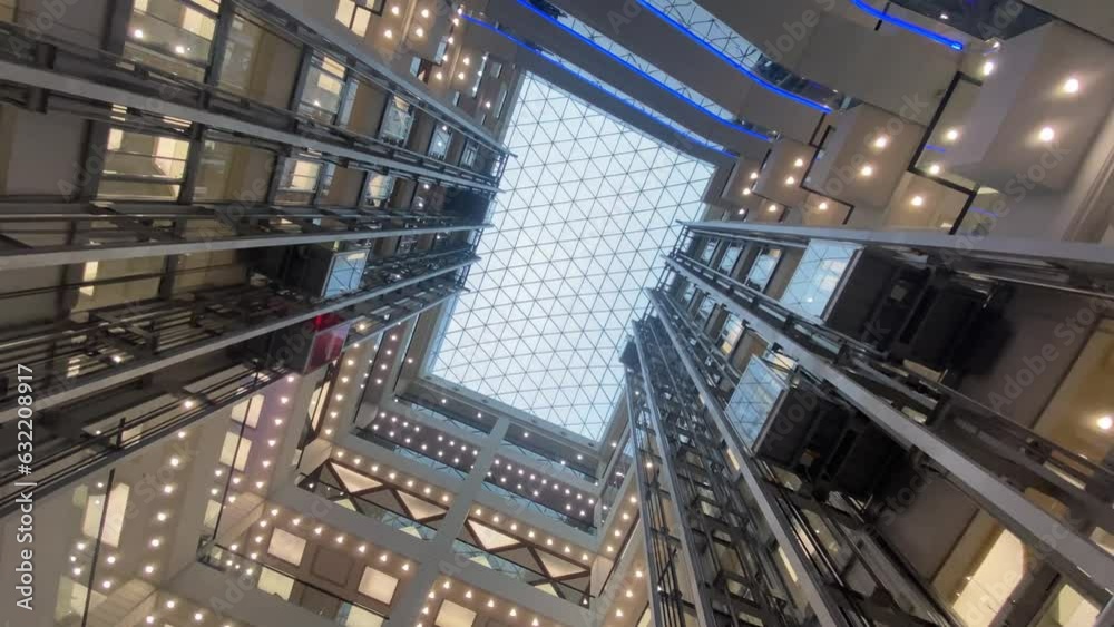 Moving up the escalator with glass sides and metal steps Moving up the escalator with glass sides and metal steps