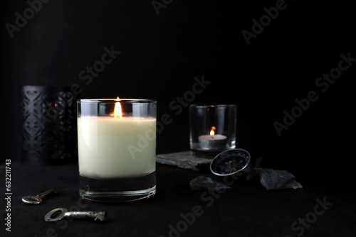 aromatic scented glass candles are on black table with many stones and background of black wall of house in bed room to creat relax and romantic moment for lovers on Valentine day