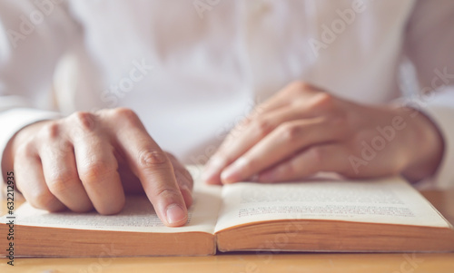 close up young man hand open bible book and reading sentence and worship in the church for hope an religion of christian concept
