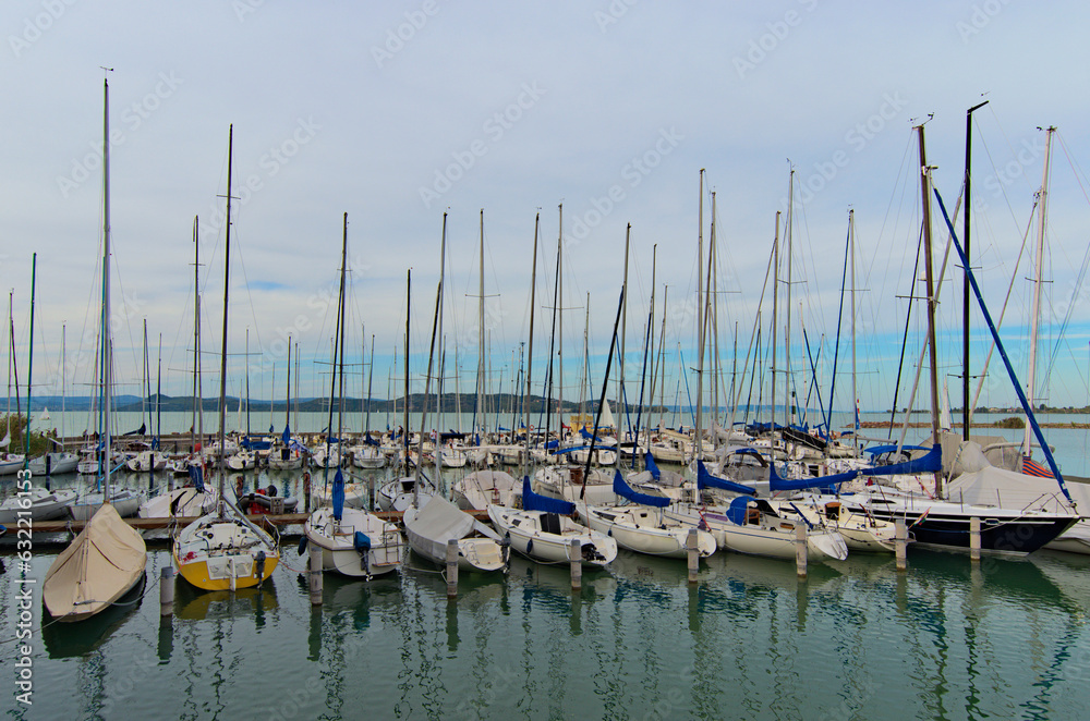 Wide-angle landscape view of anchored yachts in a harbor of yacht club in Lake Balaton, Balatonkenese. Stunning autumn landscape. Famous touristic place and romantic travel destination
