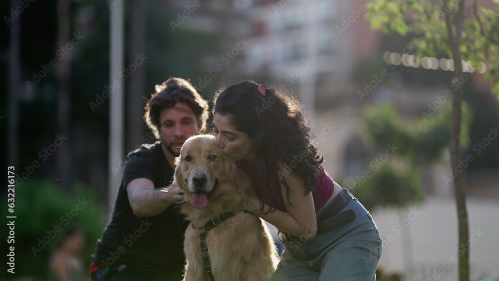 Woman kissing her beautiful Dog outside at park. Couple enjoying weekend activity. Person embracing Golden Retriever pet Woman kissing her beautiful Dog outside at park. Couple enjoying weekend activity. Person embracing Golden Retriever pet
