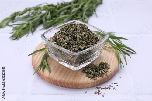 Dry and fresh tarragon on white tiled table