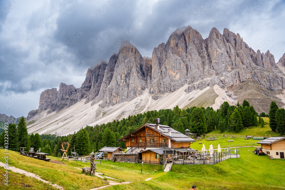 Dolomite landscape in Puez Odle Nature Park - view from alpine plateau with wooden houses and green meadows