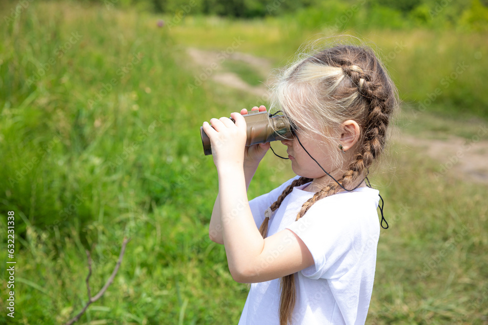 Little girl with binocular looking for the right path in summer park outdoor. Child exploring forest nature and environment on sunny day during outdoor ecology Little girl with binocular looking for the right path in summer park outdoor. Child exploring forest nature and environment on sunny day during outdoor ecology