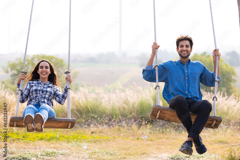 romantic couple in love sitting on rope swing. love, relationship. Hispanic latin male and woman