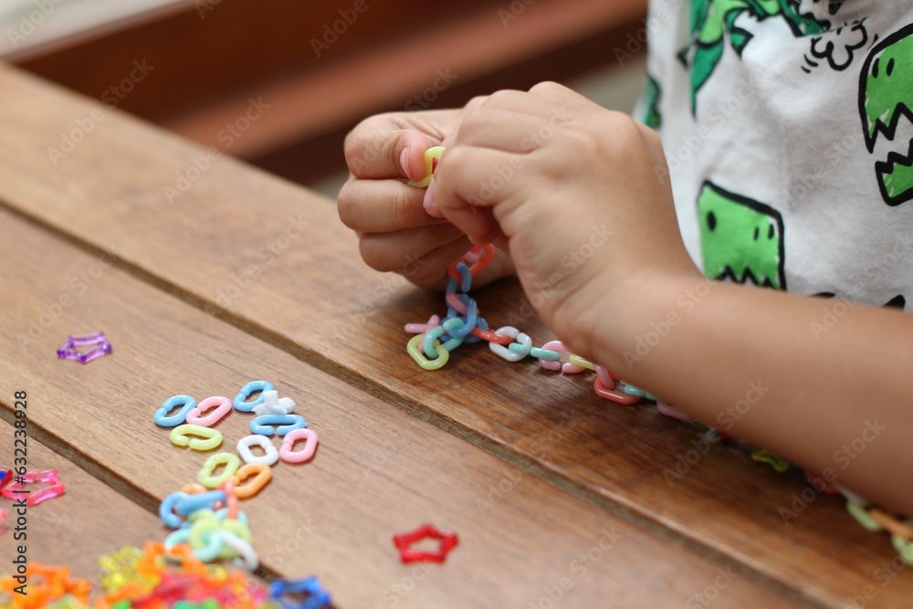 A little boy is playing with colorful plastic chain toy A little boy is playing with colorful plastic chain toy