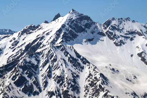 View of the snow-capped peaks of the Greater Caucasus Range on a July afternoon. Kabardino-Balkaria, Russia photo