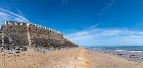 Saint-Aubin-Sur-Mer, France - 07 20 2023: View of the stone jetty and the sea from the beach .