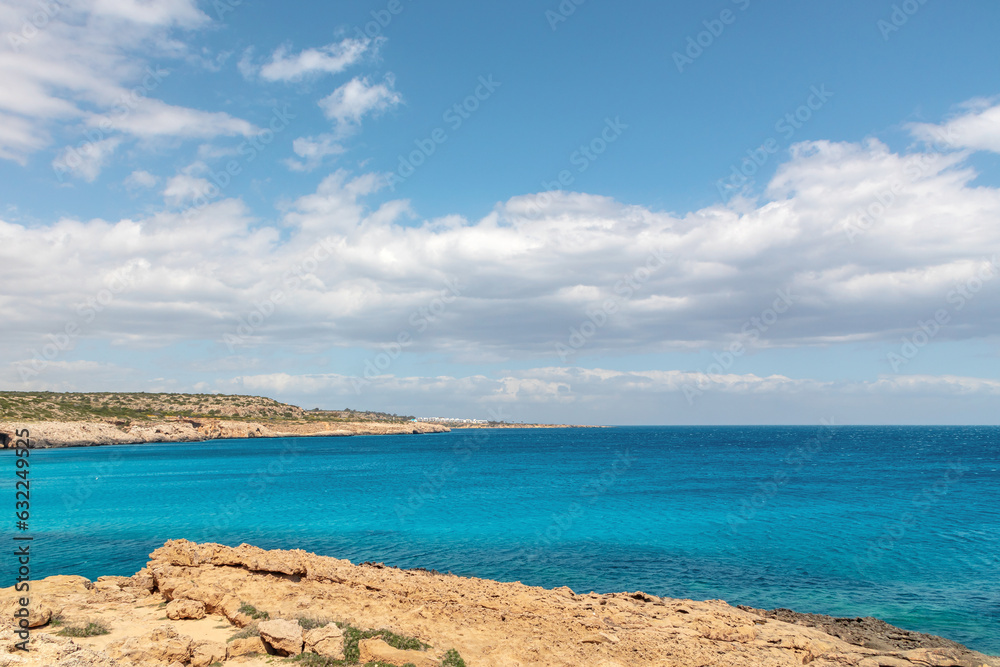 Nature landscape of the blue lagoon between the rocky bay. View of the sea with turquoise blue water on a sunny day, blue sky with white clouds in the background
