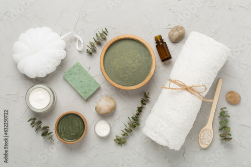 Composition with cosmetic clay and spa products on concrete background, top view