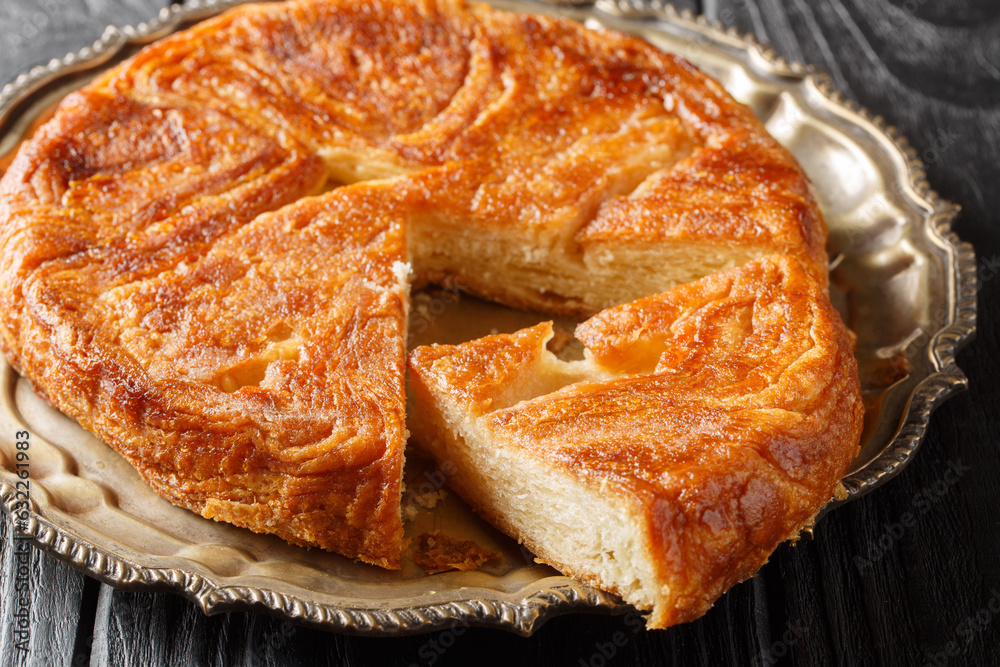 Kouign amann traditional french sweet cake closeup on the plate on the table. Horizontal Kouign amann traditional french sweet cake closeup on the plate on the table. Horizontal