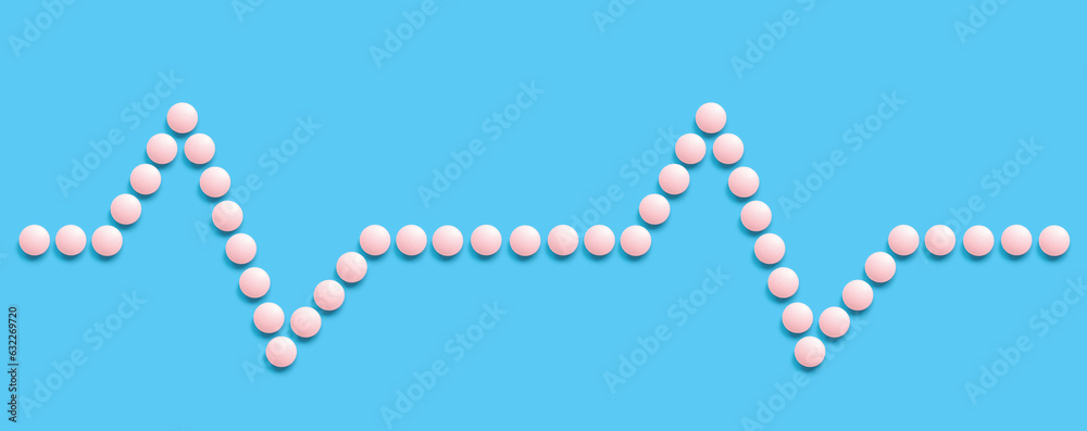 A group of pink round pills forms a pulse line on a blue background. The theme of healthcare, treatment and prevention of diseases. World Heart Day A group of pink round pills forms a pulse line on a blue background. The theme of healthcare, treatment and prevention of diseases. World Heart Day