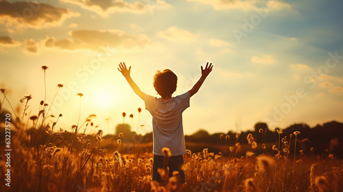 Little boy raising hands over sunset sky, enjoying life and nature. Happy Kid on summer field looking on sun. Generative AI photo