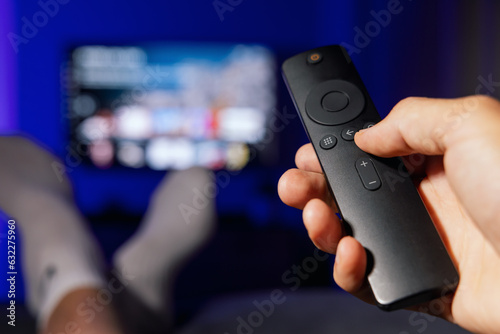 Wallpaper Mural hand with tv remote control. man watching streaming service content at home Torontodigital.ca
