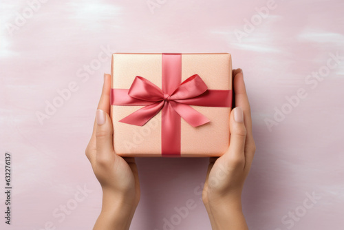 Beautiful golden gift box with red ribbon in woman's hands Generative AI © Lana_M