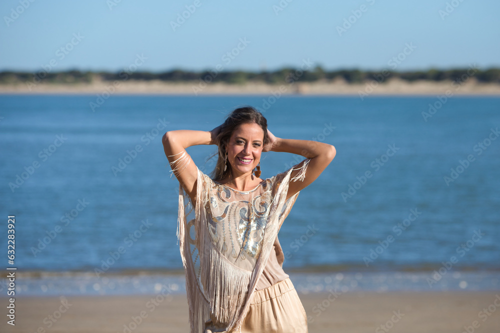 Beautiful young blonde woman walks along the shore of the beach on the south coast of Spain. The woman is happy and smiling and enjoys the sunny day. Travel and holiday concept. Beautiful young blonde woman walks along the shore of the beach on the south coast of Spain. The woman is happy and smiling and enjoys the sunny day. Travel and holiday concept.
