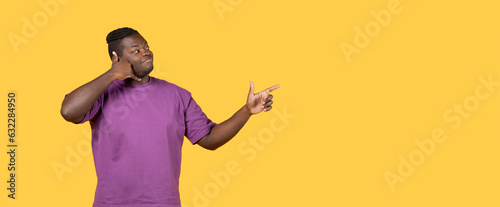 Black guy showing call me gesture pointing aside in studio