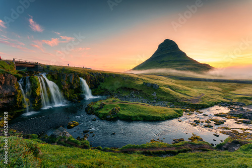 Sunrise over volcanic Kirkjufell mountain with waterfall flowing and foggy in summer at Iceland © Mumemories