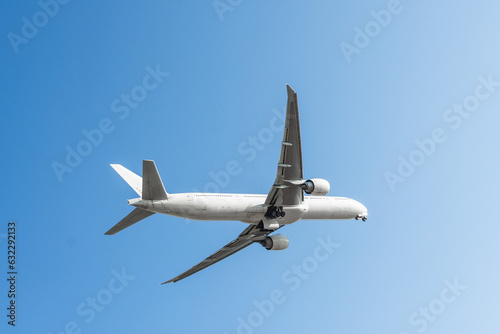 Beautiful Panoramic Background with flying plane in blue sky. Passenger airplane with landing gear released takes off in sky. Travel concept.