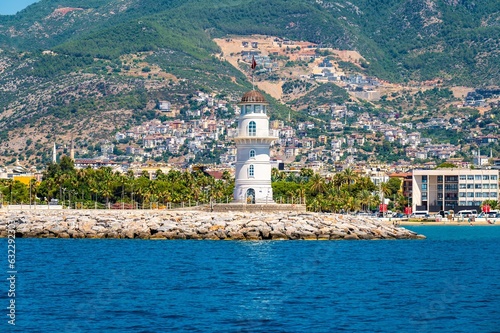 Alanya lighthouse on Alanya houses, beaches and mountain hills background at sunny day. Old lightshouse Alanya sea view photo