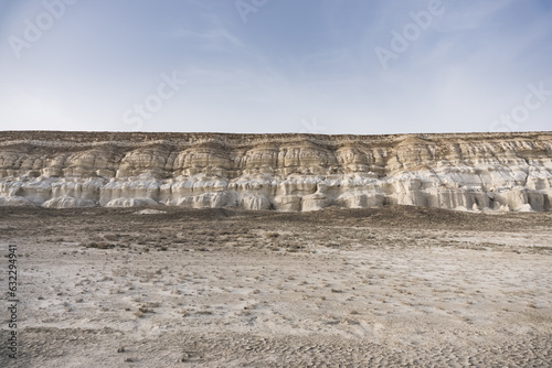 Panoramic view of the Kazakh steppe with ditches from the water and chalk slopes, the shape of limestones in the evening in the steppe