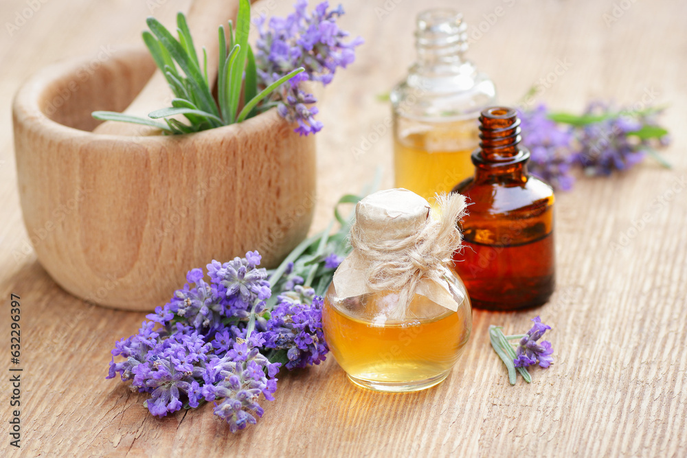 Lavender essential oil and extract in glass bottle with fresh flower and leaf on rustic wooden background, closeup, spa, skin care, aroma therapy, beauty treatment concept Lavender essential oil and extract in glass bottle with fresh flower and leaf on rustic wooden background, closeup, spa, skin care, aroma therapy, beauty treatment concept